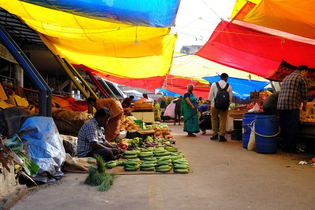 Shoppers and traders at a covered open-air produce market